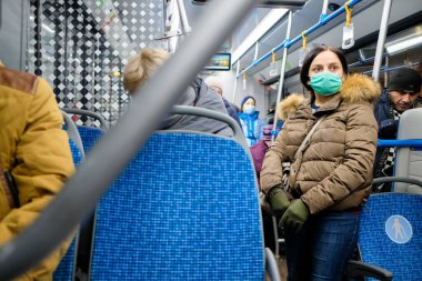 Moskova. - Rusya. 23 Kasım 2011. Tıbbi maskeli bir kadın otobüste duruyor. Kentsel toplu taşımacılıktaki virüs enfeksiyonunu en aza indirgeyecek önlemler. Koronavirüs salgını.