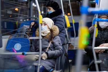 Moskova. - Rusya. 3 Aralık 2020. Toplu taşımada cerrahi koruyucu maske takan genç bir kadın. Toplu taşımacılıkta viral enfeksiyona karşı önleyici tedbirler.
