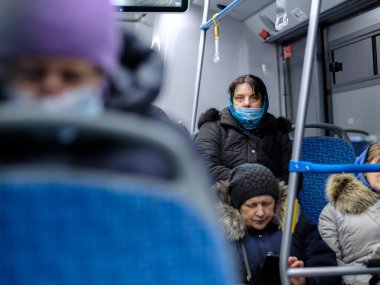 Moskova. - Rusya. 3 Aralık 2020. Yetişkin bir kadın toplu taşımada cerrahi koruyucu maske takıyor. Toplu taşımacılıkta viral enfeksiyona karşı önleyici tedbirler.