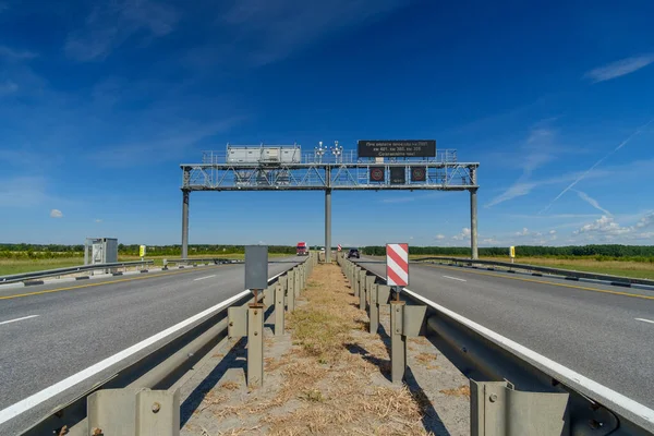 View of the highway on a summer day. Road signs over the road.