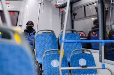 Şehir otobüsünde koruyucu bir maske takan bir adam..