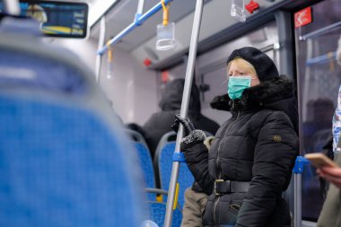 Toplu taşımada tıbbi koruyucu maske takan yetişkin bir kadın.. 