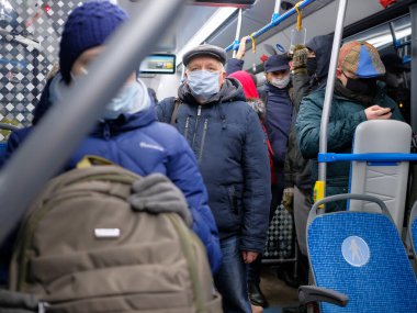 Şehir otobüsünde koruyucu bir maske takan bir adam..