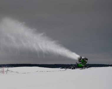 Kışın kayak yamacında kar yapma makinesi. Kar tozu püskürtüyorum.