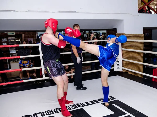 Dos hombres con uniformes de boxeo están peleando en el ring. Concursos en muay thai. —  Fotos de Stock