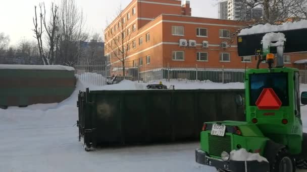 Pequeños cargadores frontales limpian la nieve de la calle y la cargan en un búnker. — Vídeos de Stock