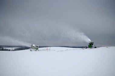 Kışın kayak yamacında kar yapma makinesi. Kar tozu püskürtüyorum.