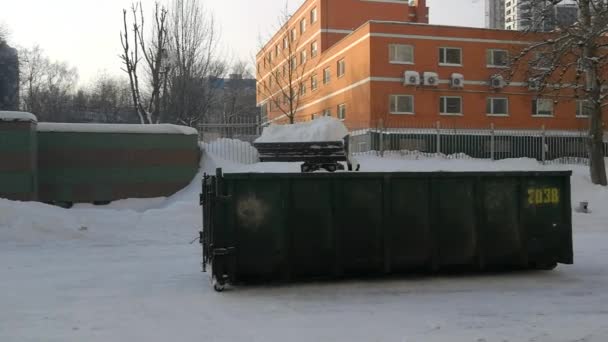 Pequeños cargadores frontales limpian la nieve de la calle y la cargan en un búnker. — Vídeo de stock