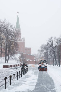 Küçük bir traktör Kremlin duvarlarının yakınındaki kaldırımdan kar temizliyor.