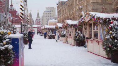 Moskova. - Rusya. 12 Şubat 2021. Bir kış günü kar yağışında çok sayıda turist Kızıl Meydan 'daki Yeni Yıl Fuarı' nda yürür. Moskova Kremlin yakınlarında GUM buz pateni pisti.