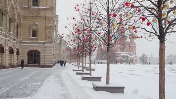 莫斯科 俄罗斯 2021年2月12日 在冬日的降雪中 红色广场的全景 人们沿着国道走在人行道上 树上五彩缤纷的气球 — 图库视频影像