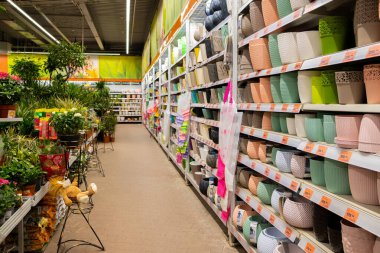 Bir bahçe mağazasının raflarında farklı boylarda ve renklerde saksılar, indirimler..