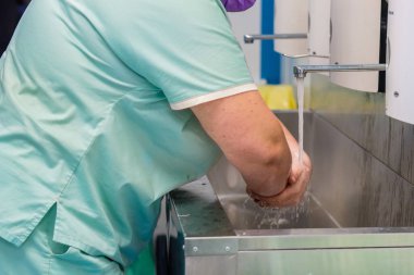 Doktor ameliyattan önce ellerini tamamen akan suyun altında yıkar..