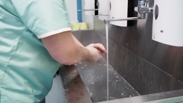 El médico se lava bien las manos bajo agua corriente antes de la cirugía.. — Vídeo de stock