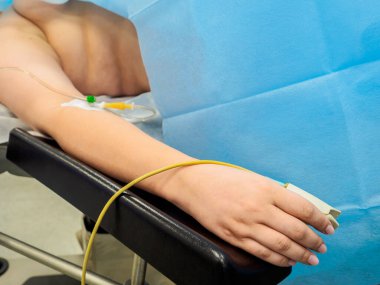 Ameliyat sırasında hastaların ellerinde nabız oksimetresi ve damar içi damlalar var..