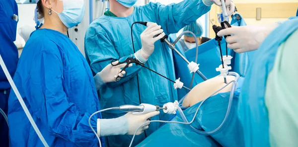 Cirujanos realizan cirugía laparoscópica usando instrumentos médicos especiales. —  Fotos de Stock