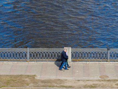 Yaşlı bir çift, şehir seti boyunca yürür..
