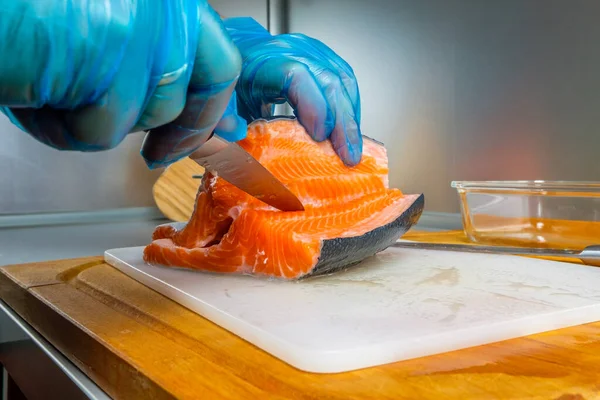 Руки кухаря відокремлюють філе лосося від кісток ножем . — стокове фото
