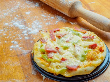 Tahta bir masada un serpiştirilmiş pizza..