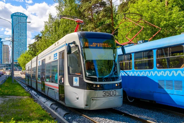 Eine moderne Straßenbahn fährt durch den Stadtpark. — Stockfoto