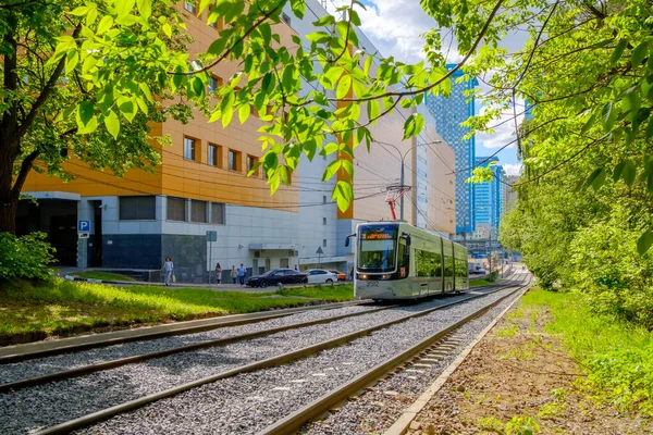 Eine moderne Straßenbahn fährt durch den Stadtpark. — Stockfoto