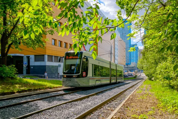 A modern tram runs through the city park. — Stock Photo, Image