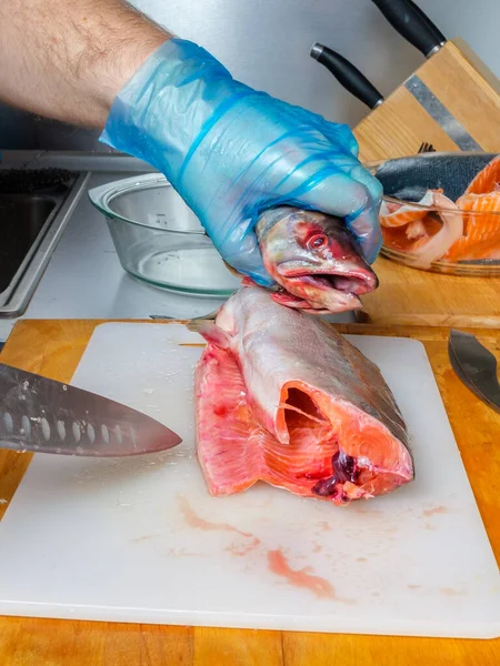 Різання свіжої риби на кухні на обробній дошці . — стокове фото