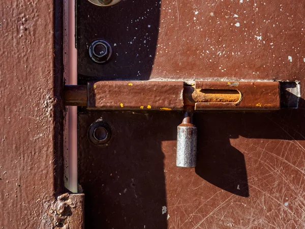 Zavřený železný závora na hnědých kovových dveřích — Stock fotografie