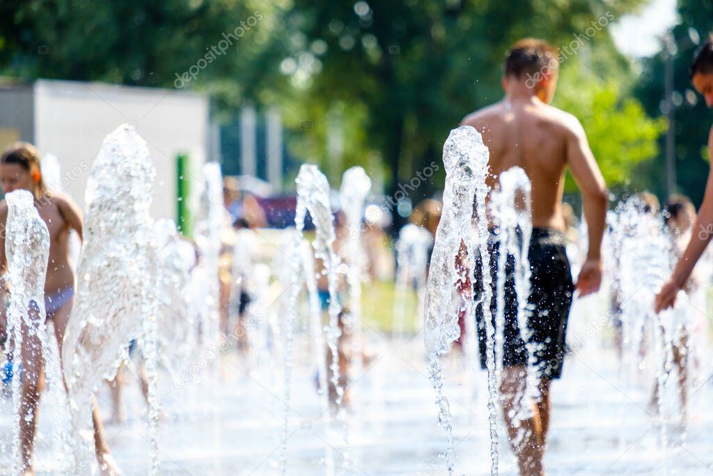 Selective focus on jets of water in a city fountain on a hot summer day.