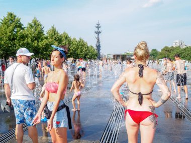 Sıcak bir yaz gününde bikinili iki güzel kadın güneşleniyor.