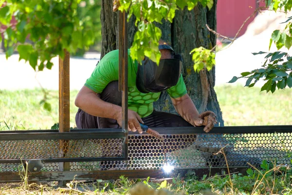 Pracovník svařuje kov s elektrickým obloukovým svařováním — Stock fotografie