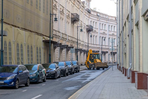 Κίτρινο τρακτέρ χρησιμότητα οδήγηση κάτω από το δρόμο στην πόλη — Φωτογραφία Αρχείου