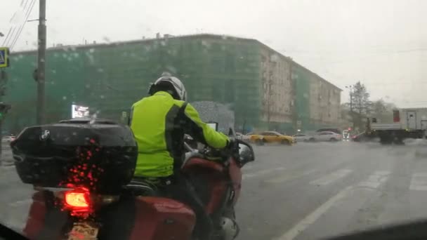 Motocyklista na motocyklu w mieście podczas deszczu. — Wideo stockowe