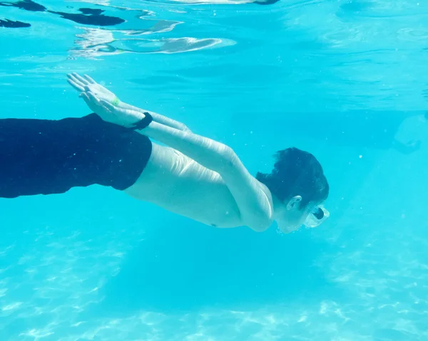 Niño nadando bajo el agua en el océano — Foto de Stock