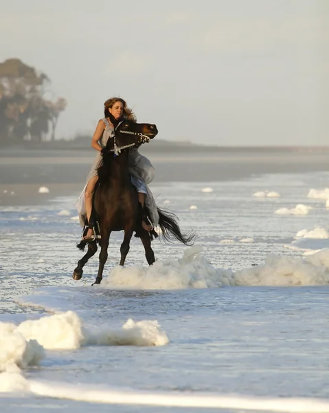 Vrouw wild paard rijden op strand — Stockfoto