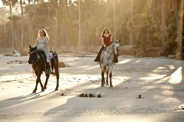 Mulheres montando cavalos na praia — Fotografia de Stock