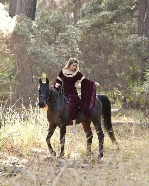 Medieval woman riding horse in forest — Stock Photo, Image