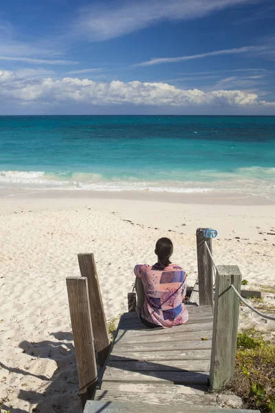 Kvinnan tittar över tropisk strand — Stockfoto