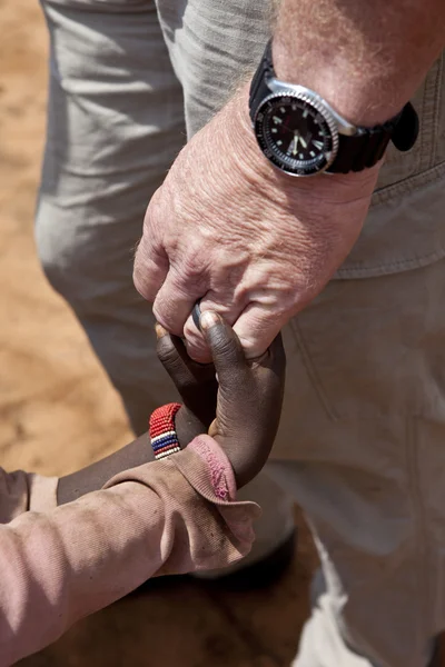 Les mains du travailleur humanitaire tenant les mains des enfants — Photo