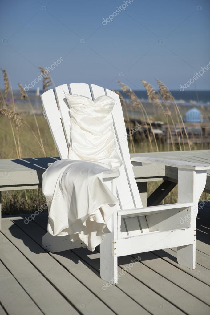 wedding dress draped over beach chair