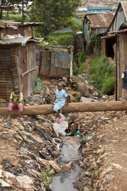 kids playing near filthy water, Kenya clipart