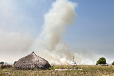 grassfire and village in south sudan clipart