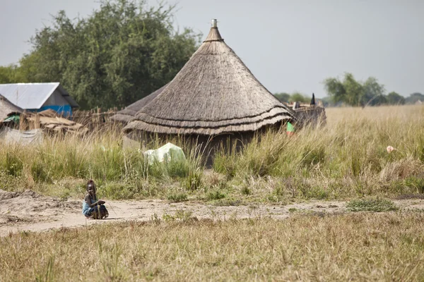 小さな女の子と南スーダンの小屋 — ストック写真