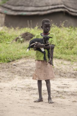 Keçi besleyen Afrikalı çocuk