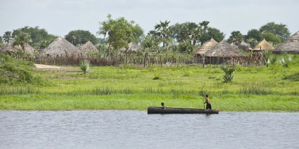 Діти, веслуванням на каное і село в Африці — стокове фото