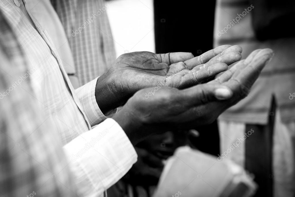hands of man praying in South Sudan