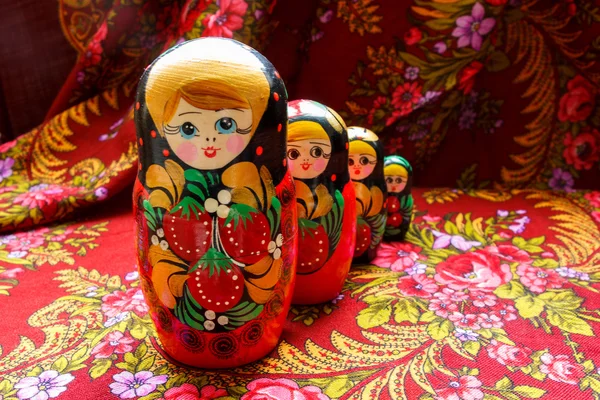 Four nesting dolls of various sizes on a red floral background — Stock Photo, Image