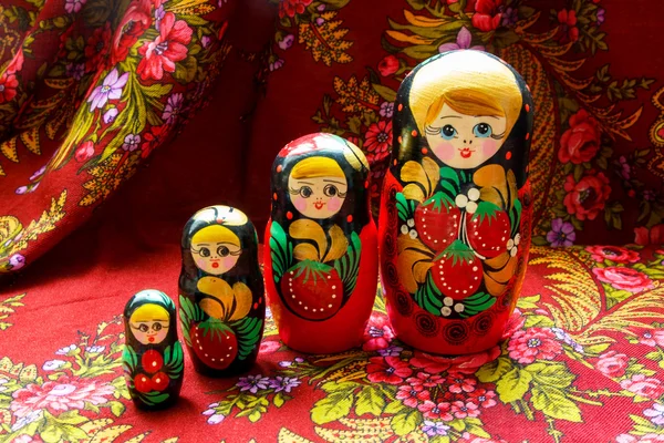 Four nesting dolls of various sizes on a red floral background - Stok İmaj