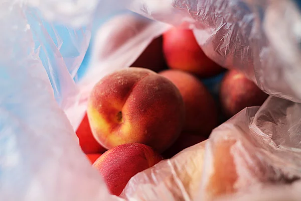 Персики в полиэтиленовой сумке — стоковое фото