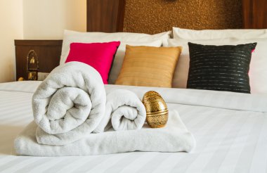 Beyaz yatakta rulo havlu